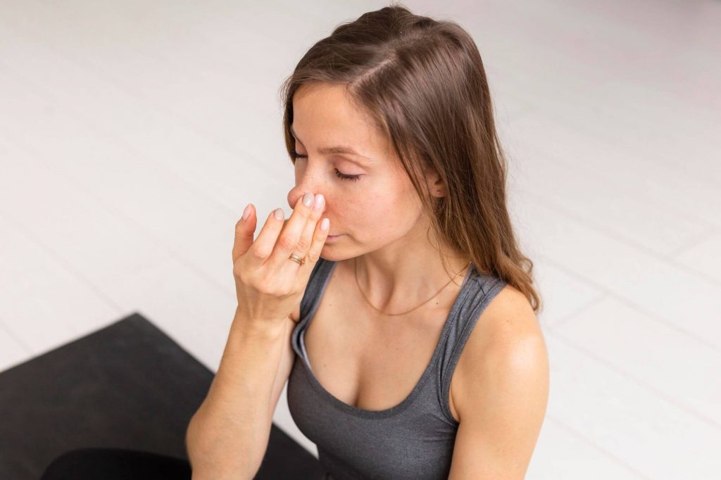 Persona tapando uno de sus orificios nasales practicando ejercicios de respiración